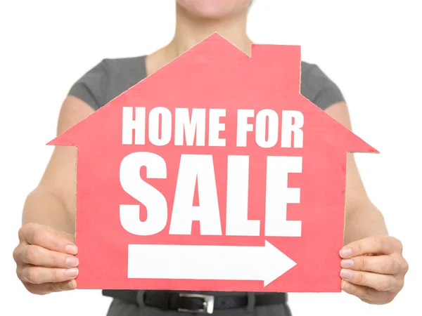 Närbild på hem för försäljning tecken i kvinnlig hand isolerade — Stockfoto