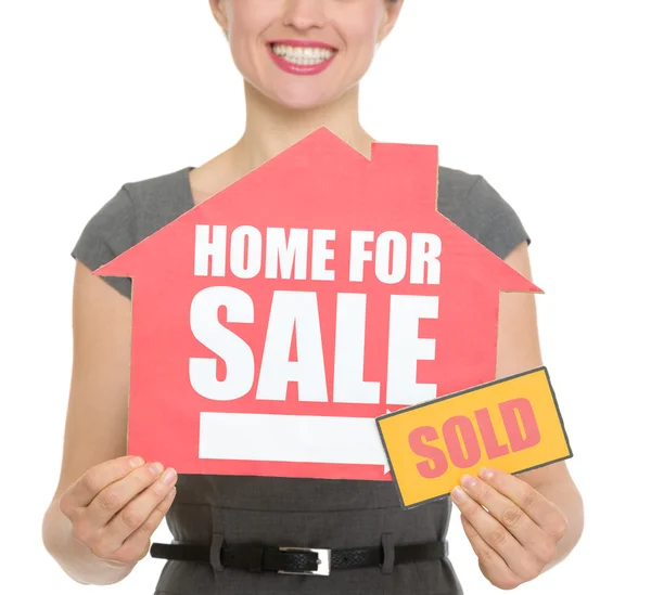Primer plano de la casa en venta venta venta letrero sosteniendo por hembra feliz aislado —  Fotos de Stock