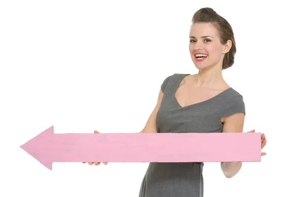 Happy business woman with big arrow pointing in corner isolated — Stock Photo, Image