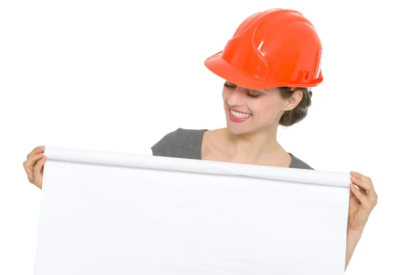 Smiling architect woman looking on blank flip chart isolated — Stock Photo, Image