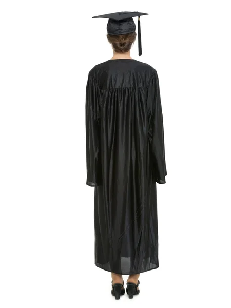 Retrato de cuerpo entero de mujer en gorra de graduación y vestido de pie detrás de la cámara — Foto de Stock