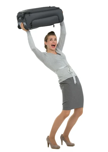 Mulher viajante levantando mala acima da cabeça — Fotografia de Stock