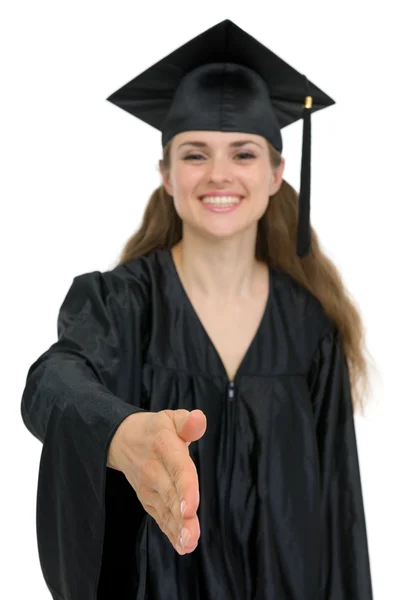 Graduação menina esticando a mão para aperto de mão. Foco na mão — Fotografia de Stock