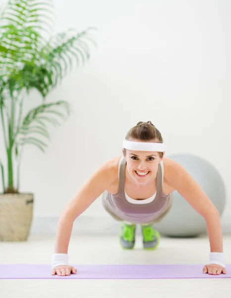 Happy fitness girl making push up exercise — Stock Photo, Image