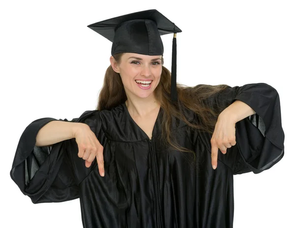 Feliz graduación estudiante mujer señalando hacia abajo — Foto de Stock