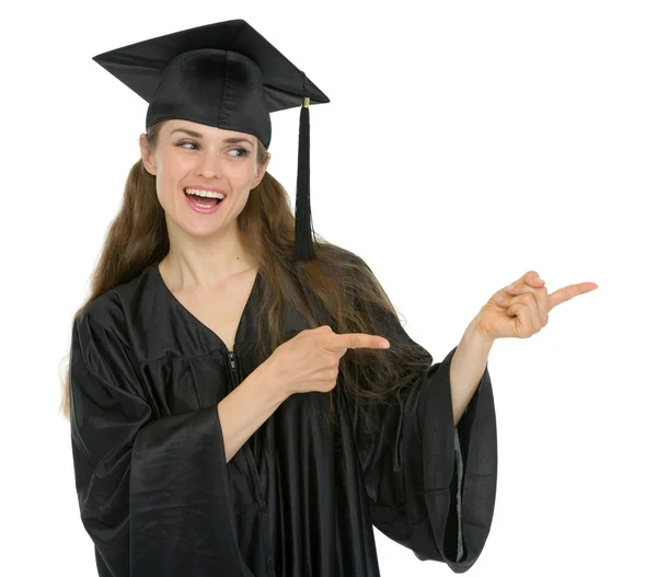 Felice laurea studentessa ragazza che punta lateralmente — Foto Stock