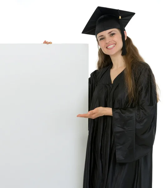Sorridente laurea studente donna mostrando su cartellone bianco — Foto Stock