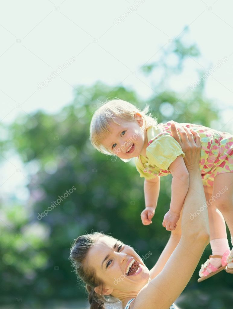 Smiling mother rising baby