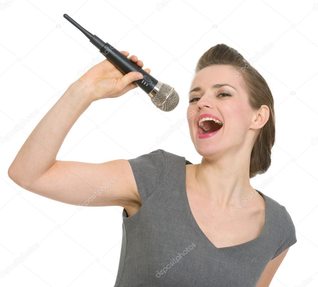 Cheerful woman singing in microphone isolated