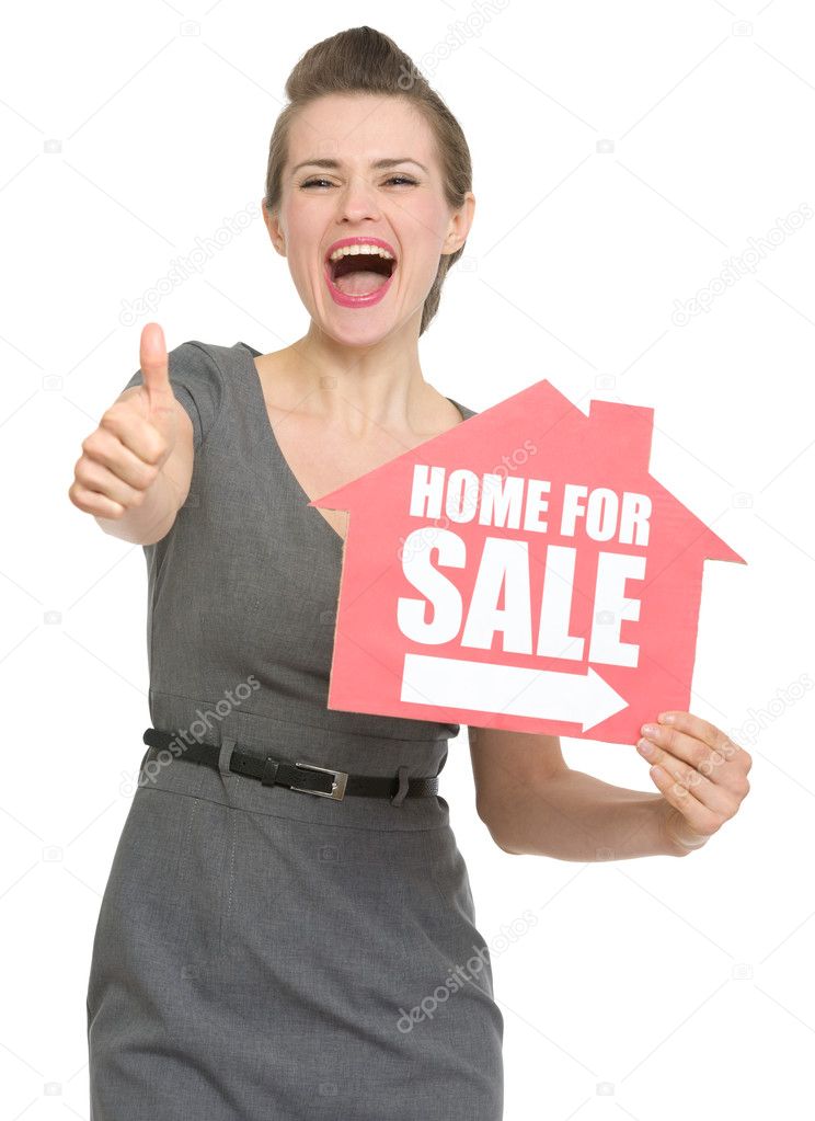 Happy realtor with home for sale sign showing thumbs up isolated
