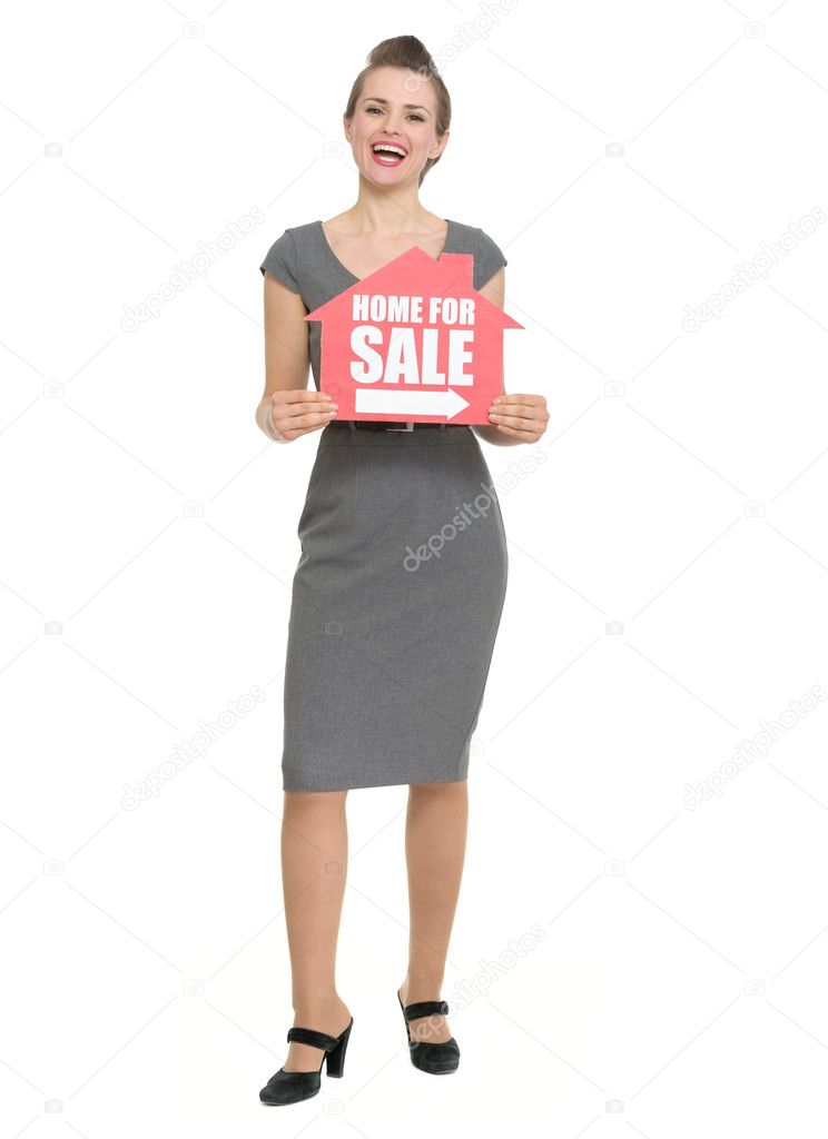 Smiling realtor with home for sale sign isolated