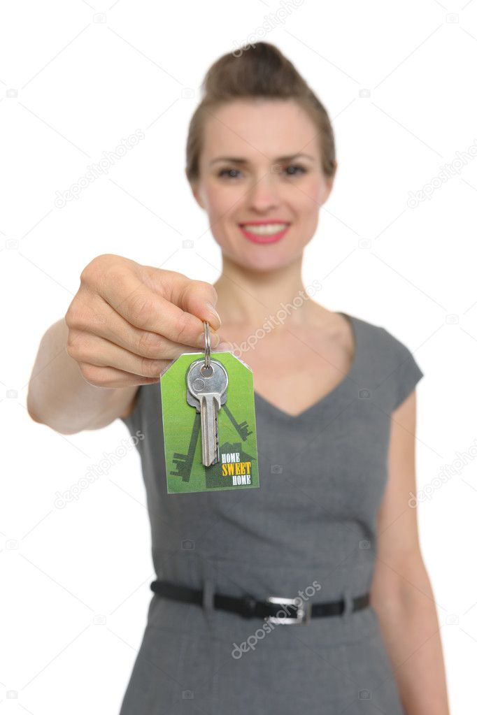Focus on keys in hand of happy woman realtor isolated
