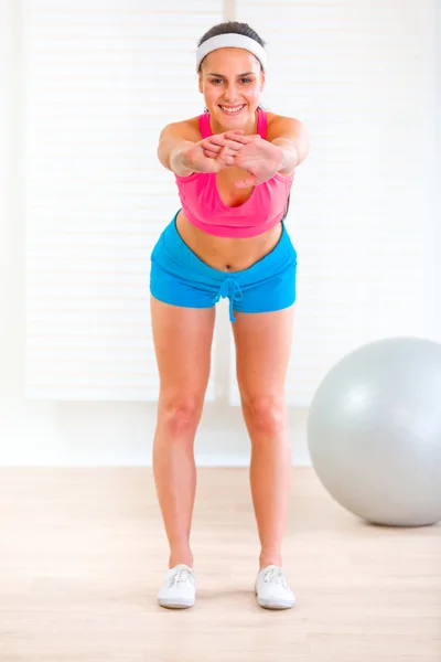 Sonriendo chica joven fitness haciendo ejercicios en casa —  Fotos de Stock