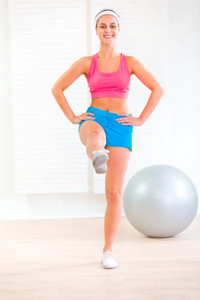 Souriant fitness jeune fille faire des exercices à la maison — Photo