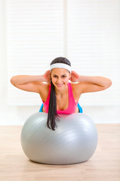 Menina fitness feliz fazendo crunch abdominal na bola de fitness — Fotografia de Stock