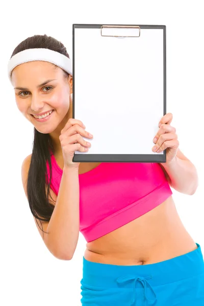 Smiling fit girl looking from blank clipboard — Stock Photo, Image