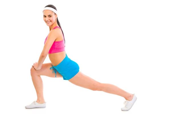 Ritratto a figura intera di femmina fitness sorridente facendo stretching — Foto Stock