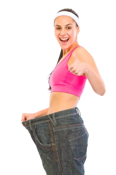 Mulher magra a puxar calças de ganga grandes. Conceito de perda de peso — Fotografia de Stock
