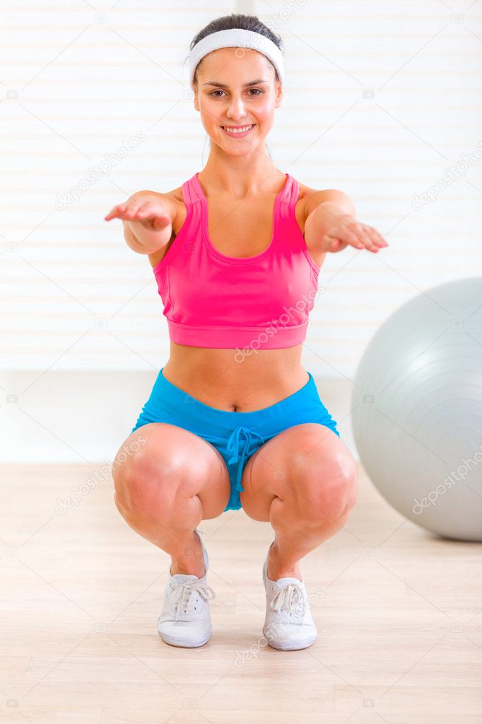 Cheerful fitness young girl doing exercises at home