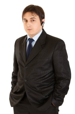 Elleri ceplerinde tutmak kulaklık ile ciddi iş adamı