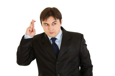 Superstitious young businessman holding crossed fingers