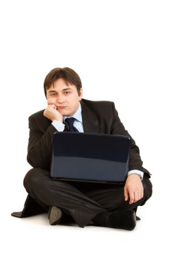 dizüstü bilgisayar ile katta oturan sıkılmış iş adamı