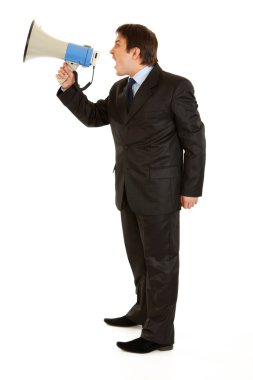 Full length portrait of frustrated young businessman yelling through megaph clipart