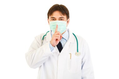 Tıp doktoru parmağı ağzında tutarak yüz maskesi. Şşş jest