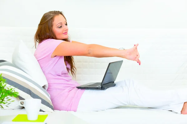 Moe van prachtige huisvrouw zittend op de Bank met laptop — Stockfoto