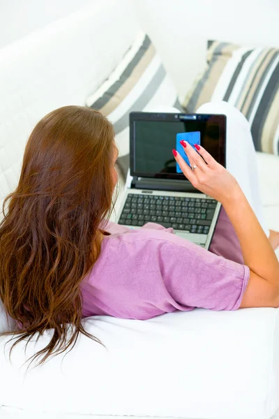 Femme assise sur le canapé et utilisant la carte de crédit pour faire des achats sur Internet — Photo