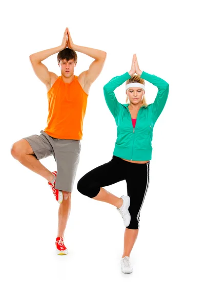 stock image Fitness girl and man in sportswear doing yoga isolated on white