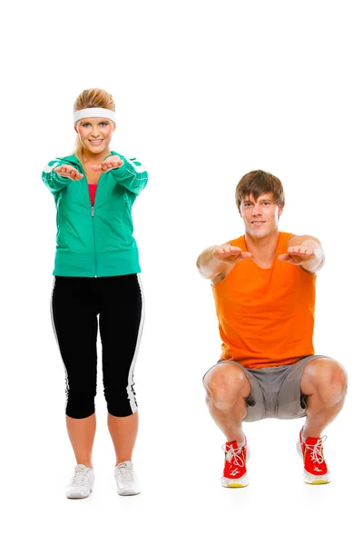 Portret van gezonde meisje en man in sportkleding zittend op squat — Stockfoto