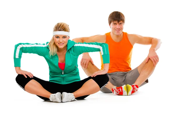 Fitness joven mujer y hombre en ropa deportiva haciendo ejercicio de estiramiento — Foto de Stock