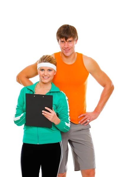 Retrato de hombre joven y chica en forma en ropa deportiva con portapapeles — Foto de Stock