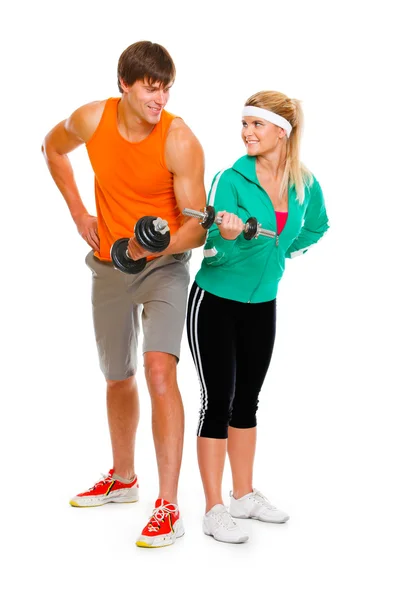 一个年轻的男人和一个健康的女孩举着一个被白色隔离的哑铃 — 图库照片