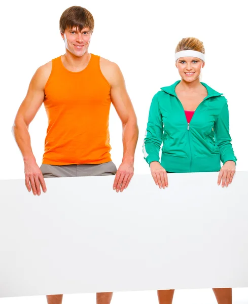 Fitness girl and male athlete with blank billboard isolated on w — Stock Photo, Image