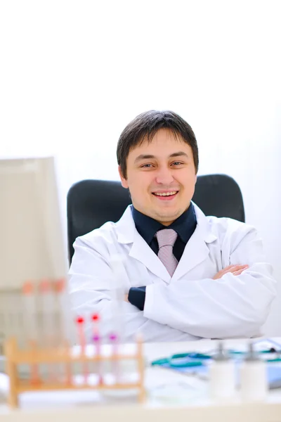 Portrét smějící se lékař sedí v kabinetu — Stock fotografie