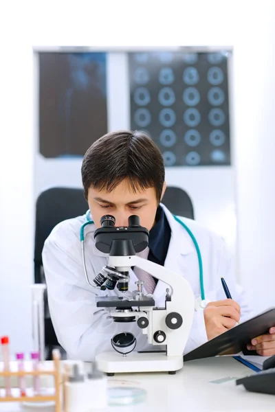 Výzkumník pomocí mikroskopu v lékařské laboratoři — Stock fotografie