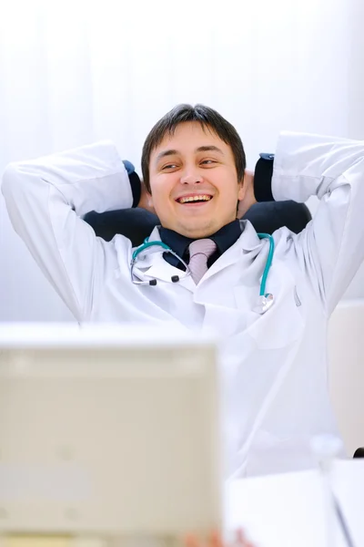 Medical doctor sitting at office table and relaxing — Stock Photo, Image