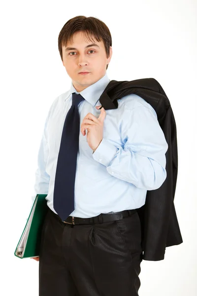 Thoughtful young businessman with jacket on his shoulder holding folder in — Stock Photo, Image