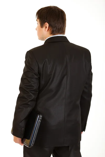 Homem de negócios moderno com laptop de pé de volta para a câmera — Fotografia de Stock
