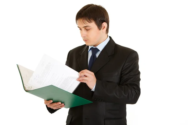 Концентрированный современный бизнесмен с папкой и проверяющими документами — стоковое фото