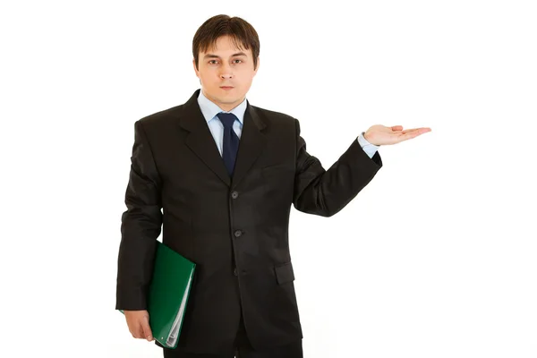 Serious businessman with folder presenting something on empty hand — Stock Photo, Image