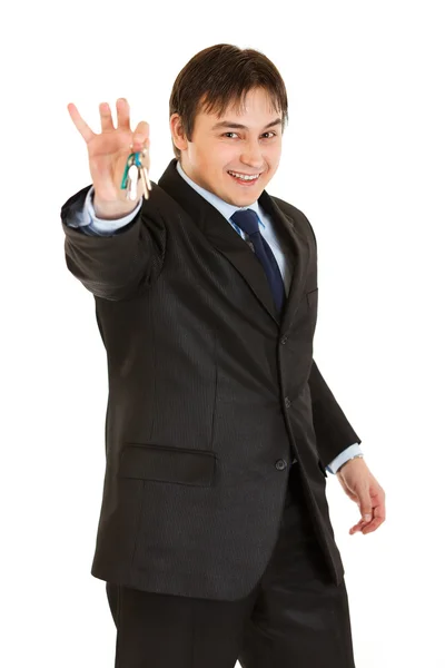 Sonriente joven empresario sosteniendo llaves en la mano — Foto de Stock