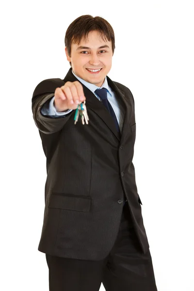 Улыбающийся молодой бизнесмен с ключами в руке — стоковое фото