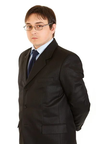 Jovem empresário sério com óculos de mãos dadas atrás das costas — Fotografia de Stock
