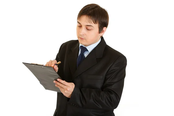 Poważny młody biznesmen, robić notatki w dokumencie — Zdjęcie stockowe