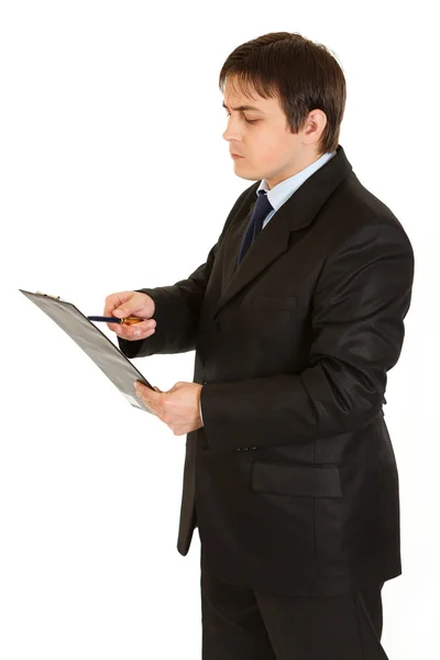 Empresario concentrado sujetando portapapeles y comprobando notas — Foto de Stock