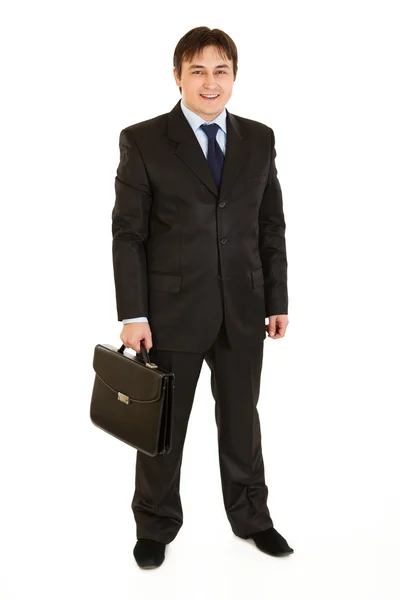 Full length portrait of smiling businessman holding briefcase in hand — Stock Photo, Image