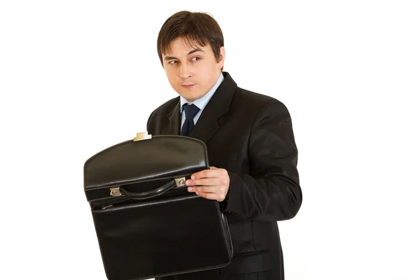 Suspicious businessman holding open briefcase in hands — Stock Photo, Image